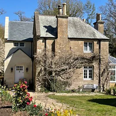 A large brick house with a garden in front of it.